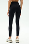 A person is shown from the back wearing SPLITS59 Easton Rigor High Waist 7/8 leggings in Black/Grass, featuring a white side stripe and compressive fabric for workout support, paired with white sneakers against a plain background.