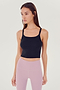 Front view of girl wearing black ribbed square neck cropped tank top with light pink leggings