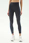 A person wearing SPLITS59 Ella High Waist Airweight 7/8 leggings in Graphite/Stone Blue with white sneakers, standing against a plain light background—ideal for hot yoga or everyday style.