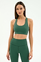 A woman wears the SPLITS59 Sara Airweight Bra in Arugula with matching high-waisted leggings, both crafted from nylon and spandex, standing against a plain light background.