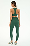 A woman stands with her back to the camera, wearing the SPLITS59 Sara Airweight Bra in Arugula and matching high-waisted leggings, made from a soft nylon-spandex blend, against a plain background.