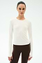 A person stands facing forward in the SPLITS59 Airweight Lite Long Sleeve Waist Length tee in white and brown leggings, ideal for gym workouts, against a plain light background.