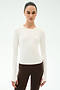 A person stands facing forward in the SPLITS59 Airweight Lite Long Sleeve Waist Length tee in white and brown leggings, ideal for gym workouts, against a plain light background.