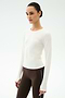 Wearing the SPLITS59 Airweight Lite Long Sleeve Waist Length in white and brown side-stripe leggings, a person stands against a light background—perfect for gym workouts.