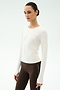 Wearing the SPLITS59 Airweight Lite Long Sleeve Waist Length in white and brown side-stripe leggings, a person stands against a light background—perfect for gym workouts.