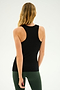 A person with long blonde hair is shown from the back, wearing a Kiki Rib Tank Full Length in Black by SPLITS59 and green leggings, standing against a plain light background, ready for some invigorating yoga.