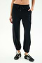 A person wears SPLITS59 Nico Airweight Cargo Pant in black for lightweight comfort, paired with black athletic shoes, standing against a plain light background.