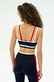 A woman with curly hair is seen from the back wearing the SPLITS59 Eva Rigor Double Strap Bra in Indigo/White—paired with high-waisted leggings, it's a stylish and comfortable choice for gym workouts that boost your confidence.