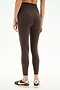Someone stands with their back to the camera in SPLITS59’s Airweight High Waist Legging - Dark Chocolate and black Nike sneakers against a white background—ideal for hot yoga sessions.