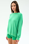 A woman stands against a white background wearing the SPLITS59 Andie Oversized Fleece Sweatshirt in Spearmint, paired with matching shorts.