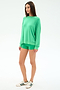 A woman stands against a white background wearing the SPLITS59 Andie Oversized Fleece Sweatshirt in Spearmint, matching green shorts made of soft modal fabric, and white sneakers with green stripes.