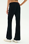 A person wearing SPLITS59 Blaire Rib Pant in black, made with soft modal and spandex, paired with white sneakers, stands on a white background, shown from the back waist down.