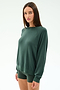 A woman with straight brown hair wears the SPLITS59 Andie Fleece Sweatshirt in Military, styled with matching fitted shorts, standing against a plain white background.
