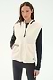 A woman stands against a plain light background wearing the SPLITS59 Aster Sherpa Vest - Creme over a black long-sleeve top and leggings—an ideal warm layer for cool weather workouts.