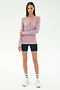 A woman stands against a plain background wearing the SPLITS59 Louise Rib Henley in blush, black biker shorts, white crew socks, and white sneakers.