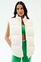 A woman models the SPLITS59 Summit Nylon Puffer Vest in white over a green sports bra and matching leggings, standing against a plain white background—ideal for lightweight insulation during cool weather workouts.