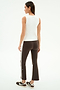 A woman faces away against a white background, wearing the SPLITS59 Carter Airweight Lite Tank in white, brown flared pants with side stripes, and brown sneakers.