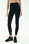 A person models the SPLITS59 Airweight Super High Waist 7/8 leggings in black with black sneakers, standing against a plain white background.