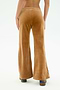 A person stands facing away from the camera, wearing SPLITS59's Joy Velour Pant in Honey—high-waisted, wide-leg brown pants made of polyester-spandex velour—paired with patterned shoes against a plain white background.