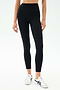 Person wearing SPLITS59 Margot Rigor Legging in Black/Dark Chocolate and white sneakers, standing against a plain light background.