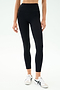 Person wearing SPLITS59 Margot Rigor Legging in Black/Dark Chocolate and white sneakers, standing against a plain light background.