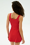 A person with curly hair is shown from behind, wearing the SPLITS59 Martina Rigor Dress in red against a plain light background.