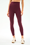 A person wears SPLITS59 Airweight Super High Waist 7/8 leggings in Dark Cherry and cream sneakers against a white background—ideal for hot yoga or everyday comfort.