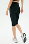 A person in SPLITS59 Airweight High Waist 16" Legging - Black, a black top, and white running shoes stands against a plain white background.