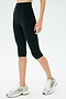 A person wearing SPLITS59 Airweight High Waist 16" Leggings in black and white running shoes stands against a plain light background.
