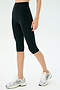 A person wearing SPLITS59 Airweight High Waist 16" Leggings in black and white running shoes stands against a plain light background.