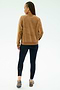 A person with braids wears the SPLITS59 Joy Velour Crewneck in Honey and black stretch leggings, standing with their back to a light background.