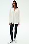 A woman stands against a white background wearing the SPLITS59 Kate Airweight Lite Button Down in white, styled as a chic layering piece with black leggings and white sneakers featuring black stripes.