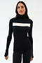 A woman wears the SPLITS59 Lennon Rib Turtleneck in Black/White, featuring a white chest stripe, against a plain light background—blending effortless style with yoga-inspired comfort.