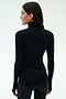 Woman stands facing away, wearing the SPLITS59 Lennon Rib Turtleneck in Black/White—sleek and fitted, ideal for yoga or running—paired with black pants against a plain light background.