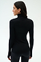 Woman stands facing away, wearing the SPLITS59 Lennon Rib Turtleneck in Black/White—sleek and fitted, ideal for yoga or running—paired with black pants against a plain light background.