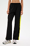 A person wearing the SPLITS59 Maxie Rigor Track Pant with gray sneakers stands against a plain background.