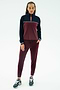 A person faces forward against a white background wearing the SPLITS59 Millie Airweight Half Zip in Dark Cherry/Indigo with matching leggings and navy sneakers.