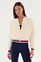 A woman wears the SPLITS59 Willa Sherpa Jacket in cream, featuring striped cuffs and waistband, styled with navy leggings against a plain white background.