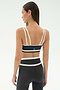 A woman faces away, wearing the SPLITS59 Eva Rigor Double Strap Bra in Graphite/White with matching high-waisted leggings—an ideal set for gym workouts.