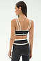 A woman faces away, wearing the SPLITS59 Eva Rigor Double Strap Bra in Graphite/White with matching high-waisted leggings—an ideal set for gym workouts.