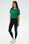 A person wearing a SPLITS59 Djuna Crop Ringer in Arugula/White and black leggings with green stripes, made from a comfortable elastane blend, stands against a plain background, paired with white sneakers.
