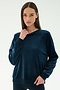 A woman wears the SPLITS59 Joy Velour Crewneck in Indigo with black leggings, standing against a plain white background.