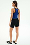 A woman faces away, wearing the SPLITS59 Kiki Rib Crop Tank in Cobalt/Black with black shorts and black athletic shoes against a plain white background.