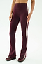 A person wears SPLITS59 Raquel High Waist Flared Legging in Dark Cherry/Creme with maroon sneakers, standing against a plain light background.