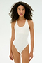A person with curly hair wears the SPLITS59 Suki Airweight Bodysuit in white, made from soft spandex, standing against a plain light background.