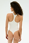 A person with curly hair stands facing away, wearing the SPLITS59 Suki Airweight Bodysuit in white, made from smooth nylon-spandex fabric, set against a plain light background.