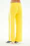 Person wears SPLITS59 Willow Airweight Wide Leg pants in Bright Yellow/White, featuring a white side stripe and soft spandex blend, paired with white sneakers, shown from the back against a plain background.