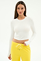 A woman wears the SPLITS59 Louise Rib Long Sleeve Crop in white with yellow drawstring pants, standing against a plain white background.