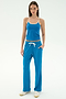 A woman faces forward in the SPLITS59 Airweight Tank - Stone Blue/White, paired with blue drawstring pants with white trim and white sneakers—ideal for hot yoga or Pilates—set against a plain white background.