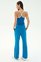 A woman stands with her back to the camera, wearing the SPLITS59 Airweight Tank in Stone Blue/White and matching wide-leg pants—ideal for hot yoga—with hands in pockets, against a plain white background.